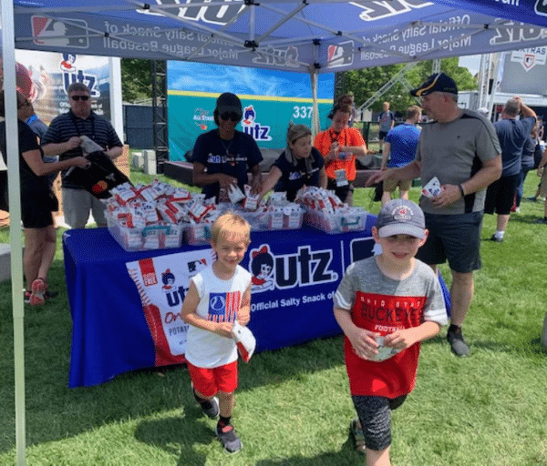 Two boys and their father carrying bags of Utz chips at a product sampling campaign pop up organized by Pro Motion.