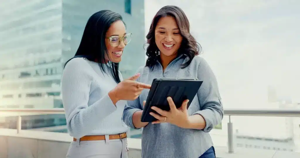 Two businesswomen working on a tablet on improving brand experience