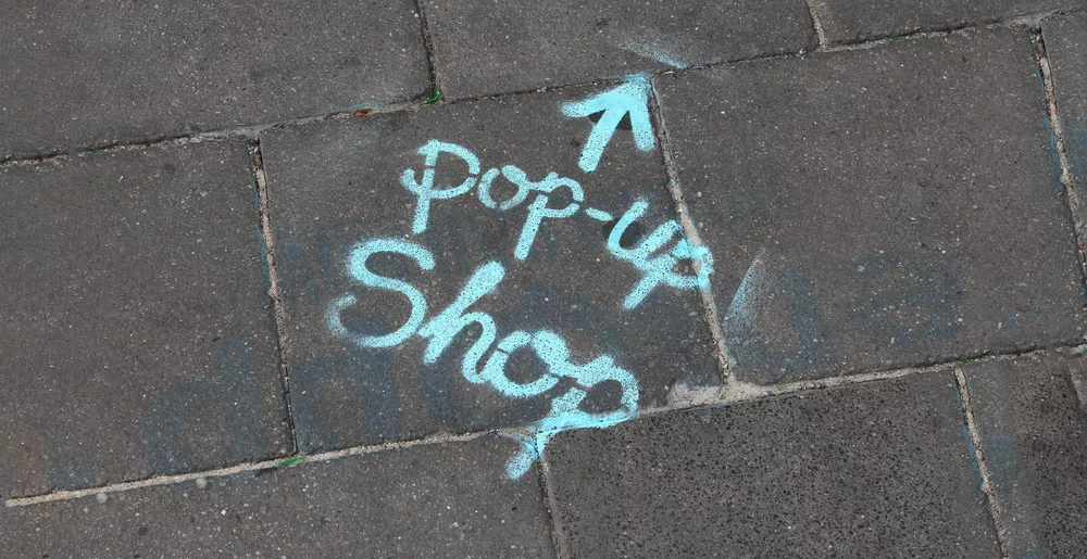 Pop-up shop sign on sidewalk